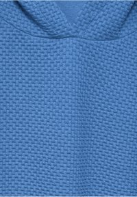 Blauw gestructureerde stof met een mandweefpatroon en een gevouwen sectie dicht bij het bovenste midden.