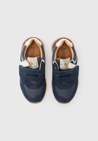 Παιδικά αθλητικά παπούτσια σε ναυτικό μπλε χρώμα με συνδυασμό σουέντ και πλέγματος, με λουράκι βέλκρο και ανοιχτό καφέ εσωτερική σόλα.