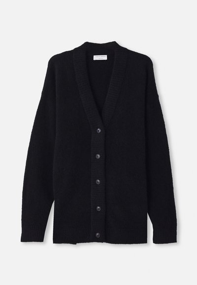 Svart kardigan laget av mykt, fluffy materiale, med dyp V-hals, ribbede mansjetter og seks frontknapper. Casual, oversized design.