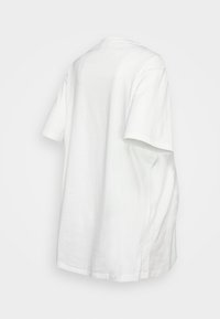 T-shirt branca feita de algodão. Mangas curtas, gola redonda e corte relaxado. Textura suave sem padrões ou adornos visíveis.