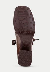 Soletta in pelle marrone con grip in gomma testurizzata, caratterizzata da motivi circolari e dal marchio impresso "HISPANITAS." Prodotto in Spagna.