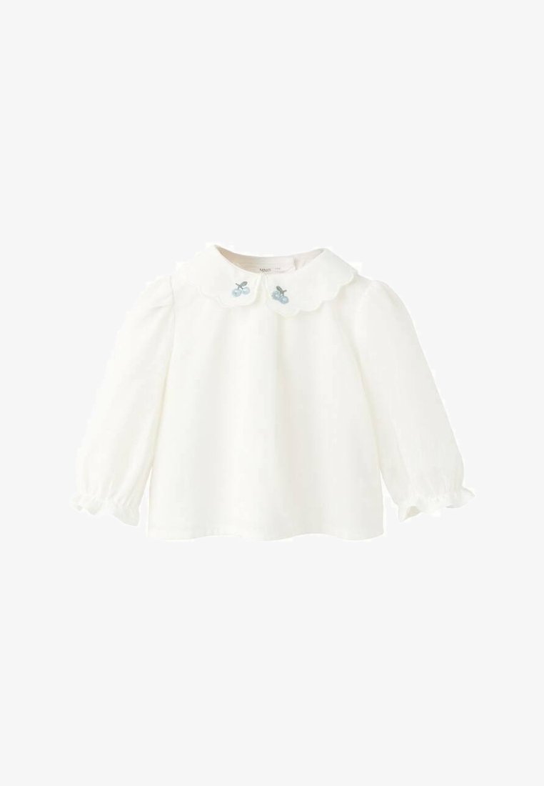 Bela majica z dolgimi rokavi z nazobčanim ovratnikom in svetlo modrimi vezenimi oblikami češenj. Mehka tkanina z nabranimi rokavi pri manšetah.