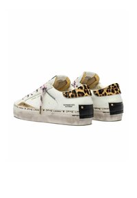 Scarpe da ginnastica bianche a low-top con lacci rosa, colletto del tallone in stampa leopardata, fascetta del tallone nera e testo "Crime London" sulle suole usurate.