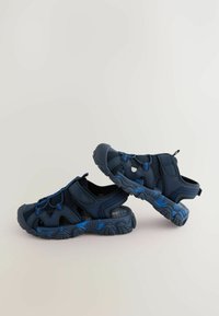 Marinblå sportiga sandaler i mesh och syntetiskt material, med en strukturerad sula och justerbara remmar för en säker passform.