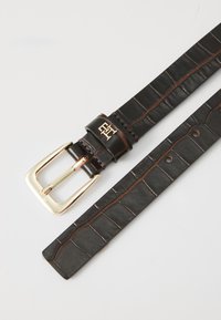Ceinture en cuir noir avec un motif crocodile, dotée d'une boucle en métal doré et d'un détail de logo. Texture lisse avec des coutures contrastées.