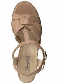 Beige sandal med vævet læderdesign, åben tå, ankelrem og justerbar spænde. Flad sål og blød inderside synlig.
