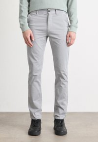 Gray cotton trousers with a slim fit, five-pocket design, button closure, and a smooth texture; paired with black sneakers.