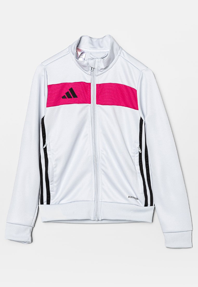 Giacca sportiva bianca con colletto alto, striscia orizzontale rosa, accenti neri sui lati e tasche con zip. Presenta polsini e fondo a costine.