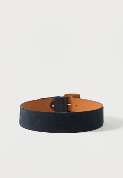 Φαρδιά ζώνη από σουέντ σε ναυτικό μπλε με ταμπά εσωτερική επένδυση δέρματος και μαύρη αγκράφα, τοποθετημένη επίπεδη σε λευκό φόντο.
