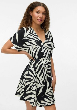 Robe imprimée zèbre en noir et blanc avec un décolleté en V, des manches courtes et une taille élastique, confectionnée dans un tissu texturé.