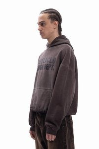 Καφέ φούτερ με κουκούλα από μαλακό ύφασμα με εμπρόσθια τσέπη, διακοσμημένο με έντονο μαύρο γραφικό κείμενο, σε συνδυασμό με σκούρο καφέ παντελόνι.