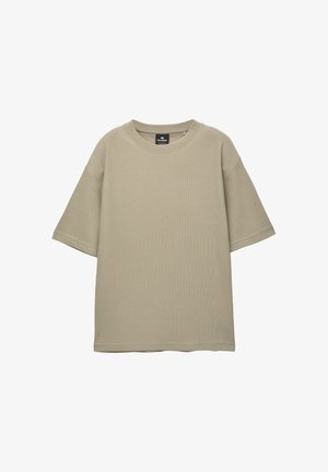 Beżowa, krótko rękawowa koszulka wykonana z fakturowanej tkaniny. Posiada okrągły dekolt oraz luźny, swobodny fason bez widocznych wzorów czy akcentów.