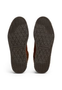 Suole in pelle marrone di sneakers con grip testurizzato, caratterizzate da un motivo a diamante e dettagli a spina di pesce. Logo "HILFIGER" incorporato.