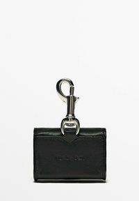 Porte-clés portefeuille en cuir noir avec un fermoir en métal argenté, arborant un logo embossé et un design minimaliste. Texture lisse et forme simple.