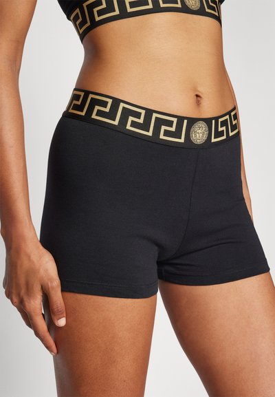 Svarta bomullsshorts med ett guldmönstrat elastiskt midjeband med grekisk nyckeldesign. Slät textur, figursydd form och midjemått längd.