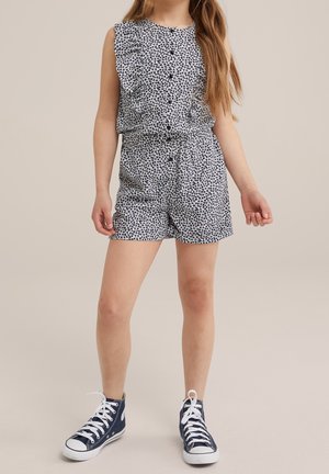 Blomstermønstrede, marineblå og hvide romper med rynkede skulderdetaljer, knapper ned foran og afslappede shorts. Sættes sammen med marineblå sneakers.