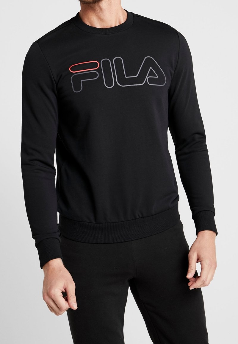 Černá mikina vyrobená z hladkého materiálu. Má kulatý výstřih, dlouhé rukávy a velké logo FILA v šedé a červené barvě na přední straně.