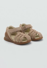 Lichtbruine suède sandalen met gesloten neuzen, klittenbandsluiting en meerdere uitsparingen voor ademend vermogen. Rubberen zool met lichte profiel.