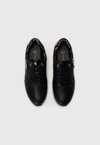 Black perforated sneakers with lace-up front and side zipper, featuring a colorful patterned lining. Rubber sole for traction and durability.