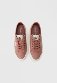 Pink synthetic sneakers with white rubber soles, round toe, lace-up design, silver eyelets, and branded accents on the tongue and side.