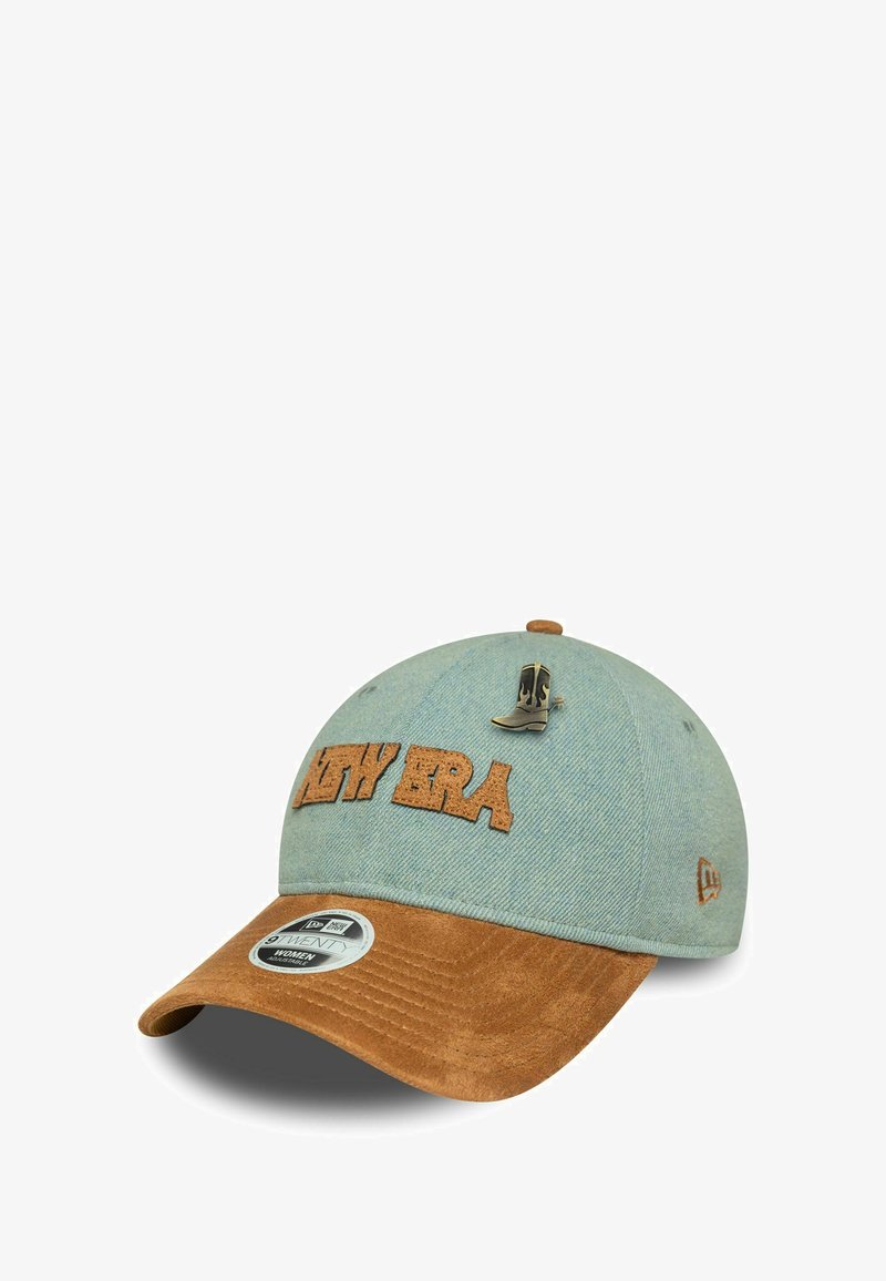 Cappello in denim con corona blu chiaro, visiera in suede marrone, logo "NEW ERA" in marrone e una piccola spilla a forma di stivale sulla parte anteriore.