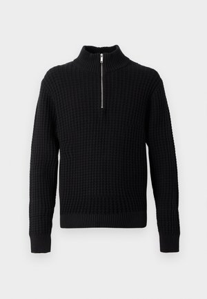 Černý pletený svetr s vysokým límcem a polozipem. Strukturovaný vaflový vzor, přiléhavé manžety a spodní lem.
