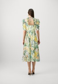 Blumenkleid in Midi-Länge in Grün-, Gelb- und Pinktönen, mit Puffärmeln, einer Bindeschließe und einem offenen Rückendesign.