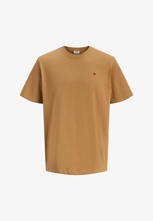 T-shirt en coton marron à manches courtes et col rond. Présente un petit point rouge sur le côté gauche de la poitrine.