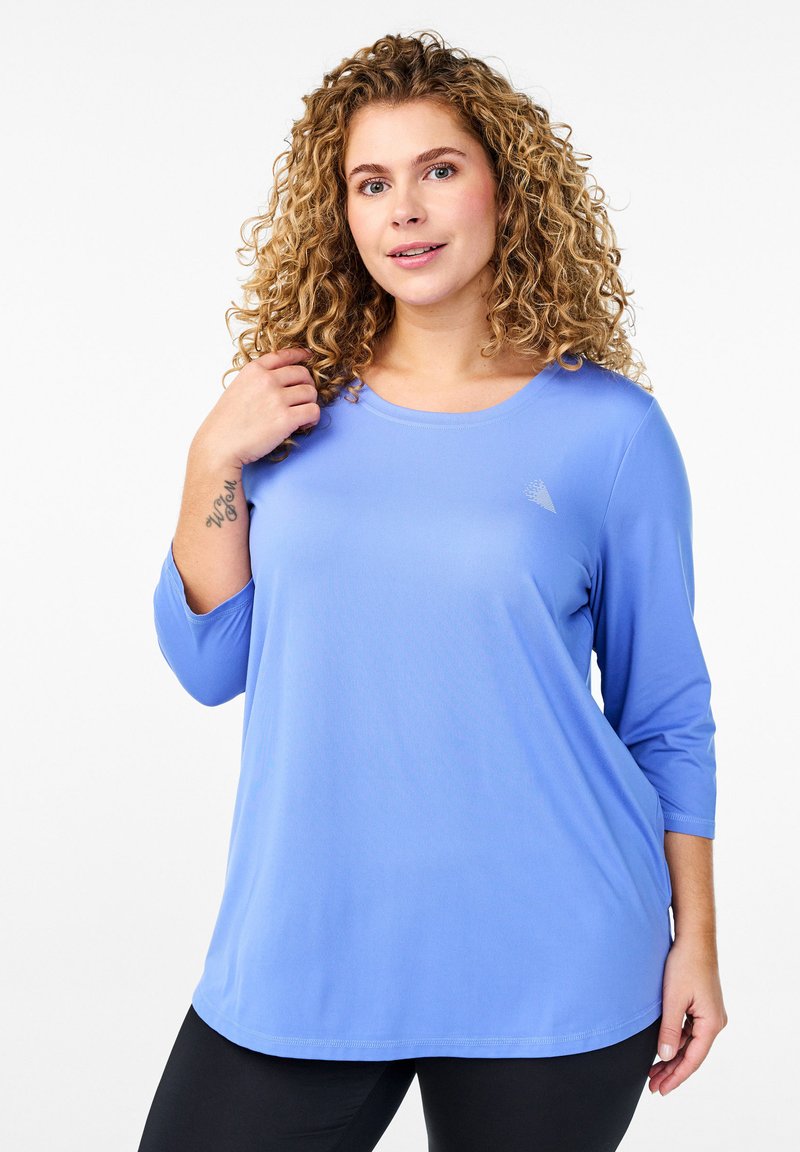 Lichtblauw sporttop met een ronde halslijn en driekwart mouwen, gemaakt van een gladde stof, met een klein logo op de borst.
