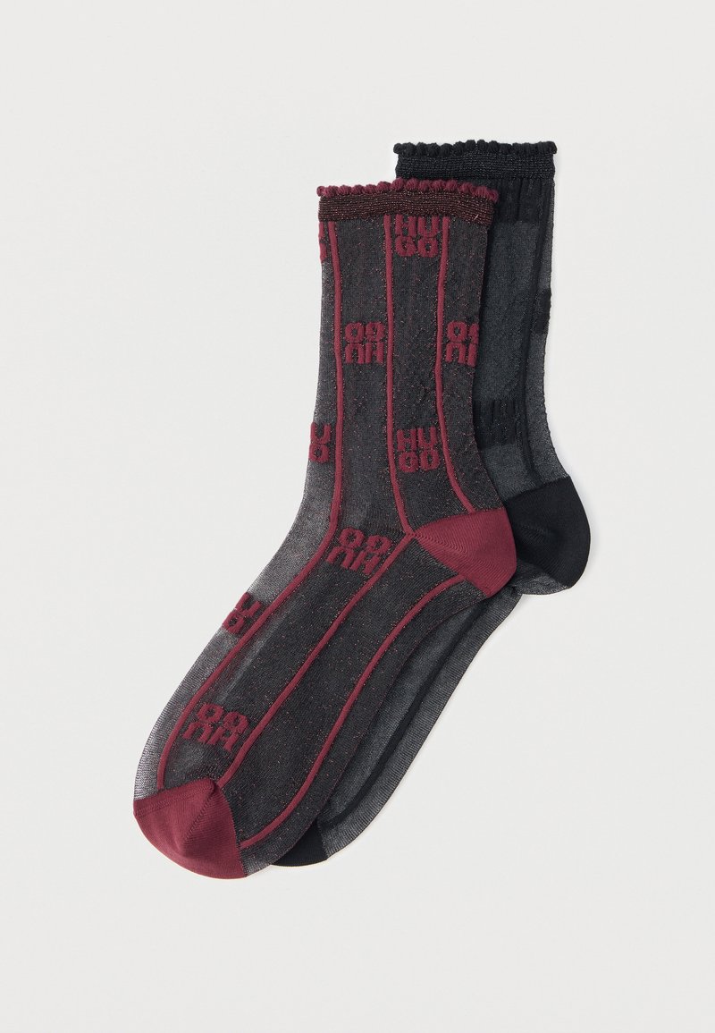 Dos pares de calcetines transparentes con estampado, uno negro con detalles burdeos y el otro gris oscuro con detalles negros, colocados planos sobre un fondo blanco.