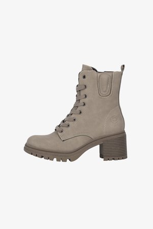 Botas tobilleras grises de cuero suave con diseño de cordones, un tacón resistente y una suela texturizada para mayor tracción. Cuenta con una lengüeta en la parte posterior.