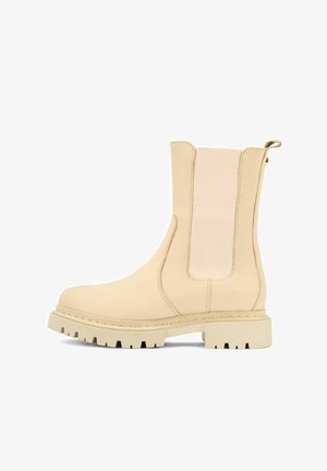 Beżowe botki za kostkę z elastycznymi wkładkami po bokach, teksturowany materiał skórzany, masywna gumowa podeszwa oraz pętelka przy pięcie ułatwiająca zakładanie.