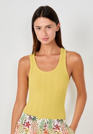 Top sin mangas amarillo acanalado con escote redondo y tirantes anchos, combinado con una falda de estampado floral con acentos coloridos.