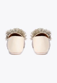 Chaussures beige en cuir à enfiler avec arrière en tissu texturé et accents décoratifs à capitons. Semelle plate avec détails subtils chatoyants.