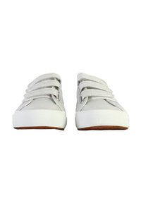 Zapatillas de lona de color gris claro con suelas de goma blancas y cordones brillantes. El diseño presenta una parte superior baja y una punta redondeada.