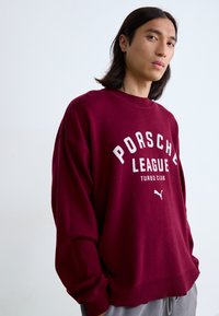 Bordeaux sweatshirt med ribbet krave og manchetter, med hvid "Porsche League Turbo Club" print og lille Puma-logo i bunden.