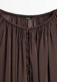 Jupe marron froncée en tissu avec taille élastique et liens à nouer, étiquette Massimo Dutti, fabriquée au Maroc.