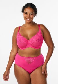 Rozač modrček iz čipke in hlačke z visokim pasom, okrašene z rožnatimi čipkastimi poudarki, kontrastnim trdnim materialom in širokimi naramnicami za podporo.