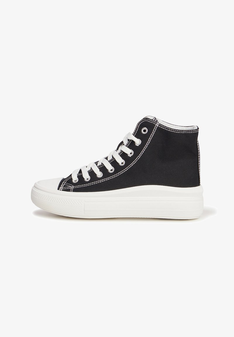 Baskets montantes en toile noire avec semelle en caoutchouc blanche et couture, dotées de six œillets et de lacets, texture lisse et design à bout rond.