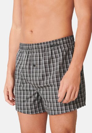 Schwarz-graue karierten Boxershorts aus leichtem Stoff, mit einem elastischen Bund und einem einzigen Knopfverschluss auf der Vorderseite.