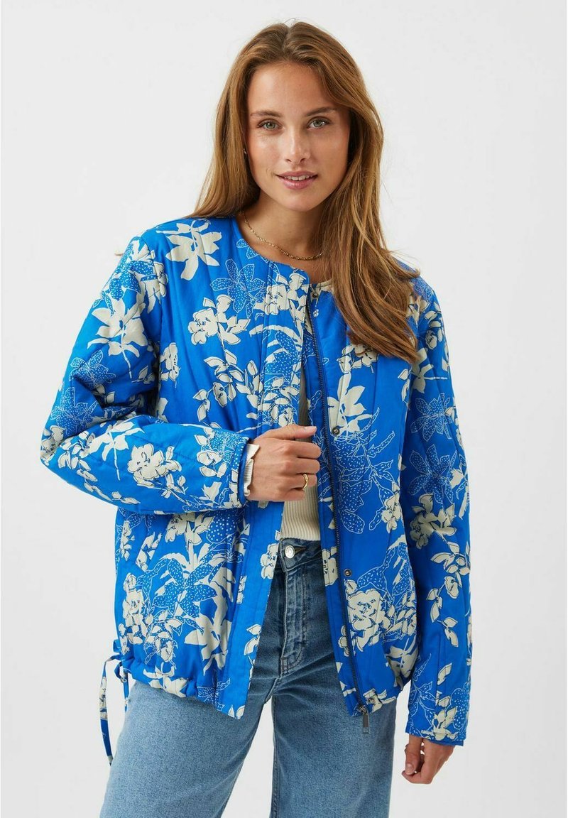 Blå polstret jakke med et blomsterprint i hvid, rund halsudskæring, lynlås lukning og snøre detaljer i siderne.