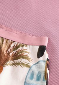 Multikleurige stof met een bloemen- en architectonische print, gecombineerd met een ribbelige roze katoenen sectie en een gladde elastische rand.