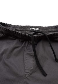 Dark gray shorts made of woven fabric, featuring an elastic waistband with a drawstring and a branded label with "HONESTY" text.