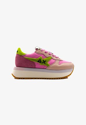 Sneakers con materiali in pelle e camoscio rosa, con un accento di logo verde, lacci rotondi e una suola spessa beige e gomma.