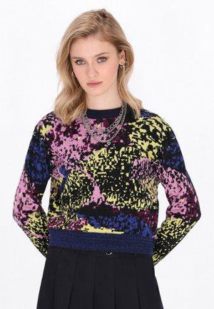 Multicolored knit sweater featuring a bold abstract pattern in pink, blue, yellow, and black, with a ribbed navy neckline and hem.