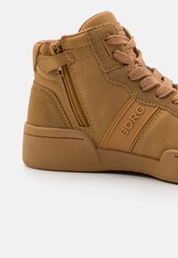 Tan hoge sneakers van suede en synthetische materialen, met een zijrits, textuuraccenten en BORG merktekens aan de zijkant.