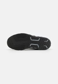 Black athletic shoe outsole with textured rubber tread; features grey accents and a patterned design for improved grip.