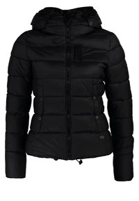 Schwarze Pufferjacke mit durchgehendem Reißverschluss, angedeuteter Kapuze und vertikaler Steppung. Verfügt über eine Brusttasche und seitliche Taschen mit Knopf.