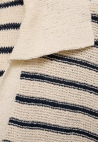 Striped cotton fabric featuring a cream base with navy blue lines, showcasing a textured knit pattern and a soft, flexible drape.