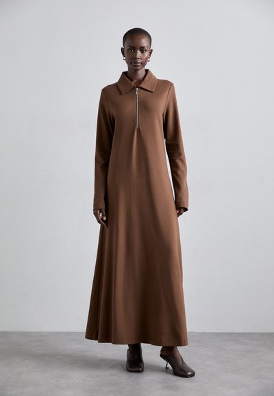 Braunes langärmliges Kleid mit Kragen und Reißverschlussdetails auf der Vorderseite, aus glattem Stoff gefertigt, mit einer fließenden Silhouette und knöchellanger Länge.
